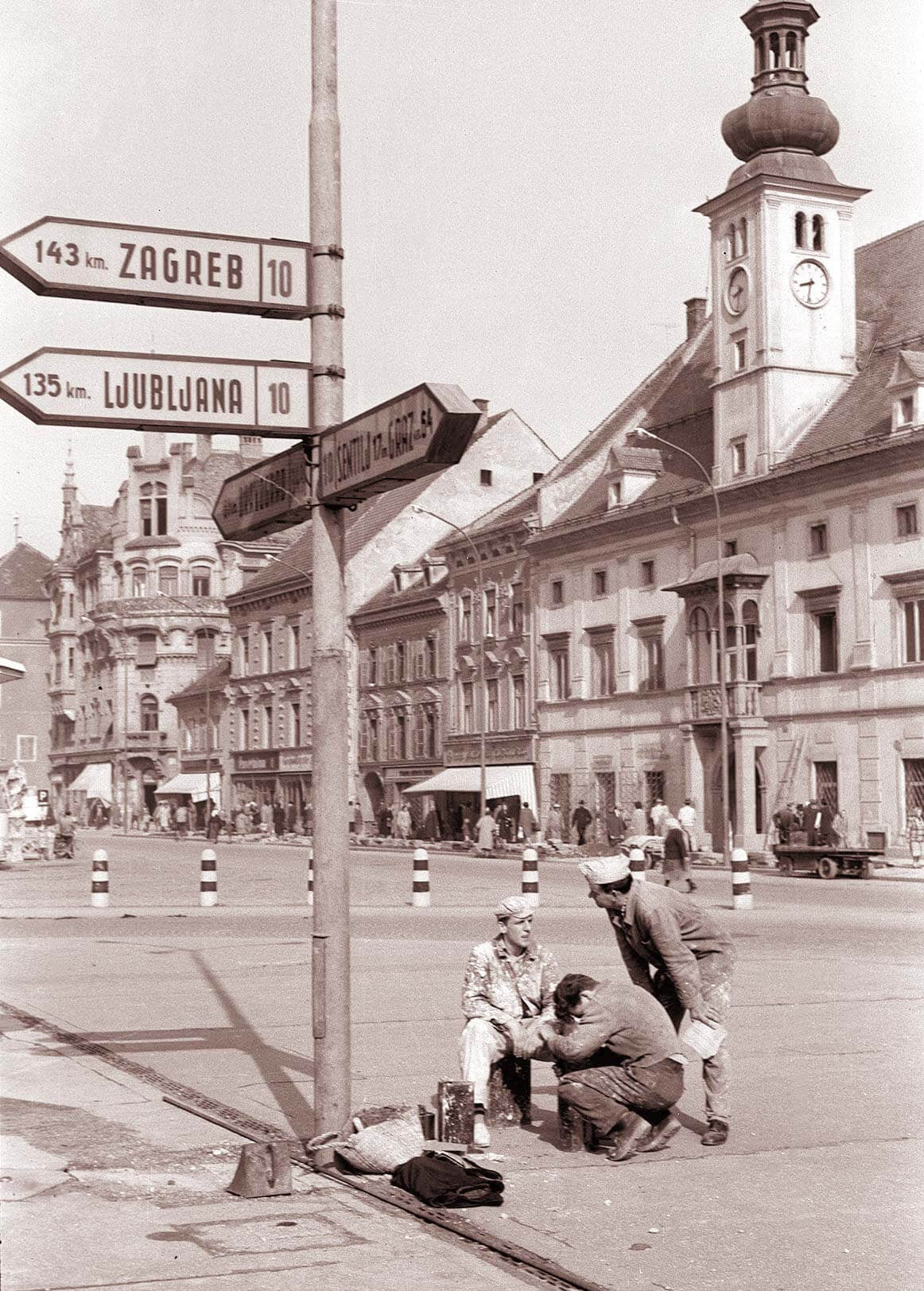 Delavci_se_pripravljajo_na_pleskanje_kandelabrov_javne_razsvetljave_na_Glavnem_trgu_1960.jpg