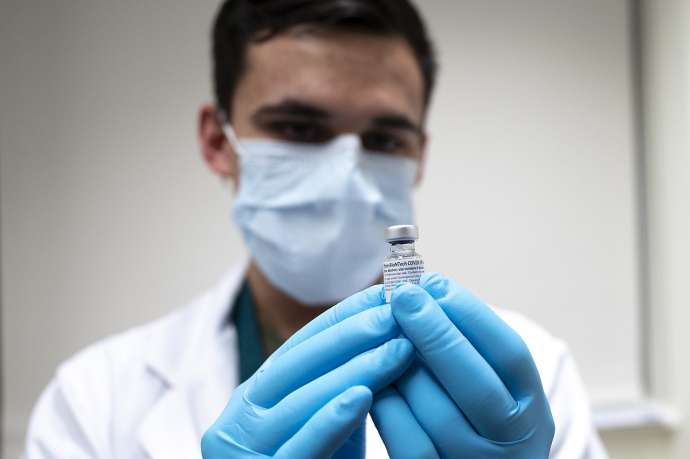 Army Spc. Angel Laureano holds a vial of the COVID-19 vaccine, Walter Reed National Military Medical Center, Bethesda, Md., Dec. 14, 2020.