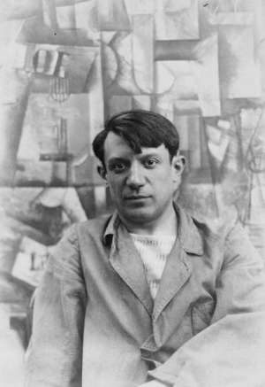 Portrait photograph of Pablo Picasso, in front of his painting The Aficionado (Kunstmuseum Basel) at Villa les Clochettes, Sorgues, France, summer 1912