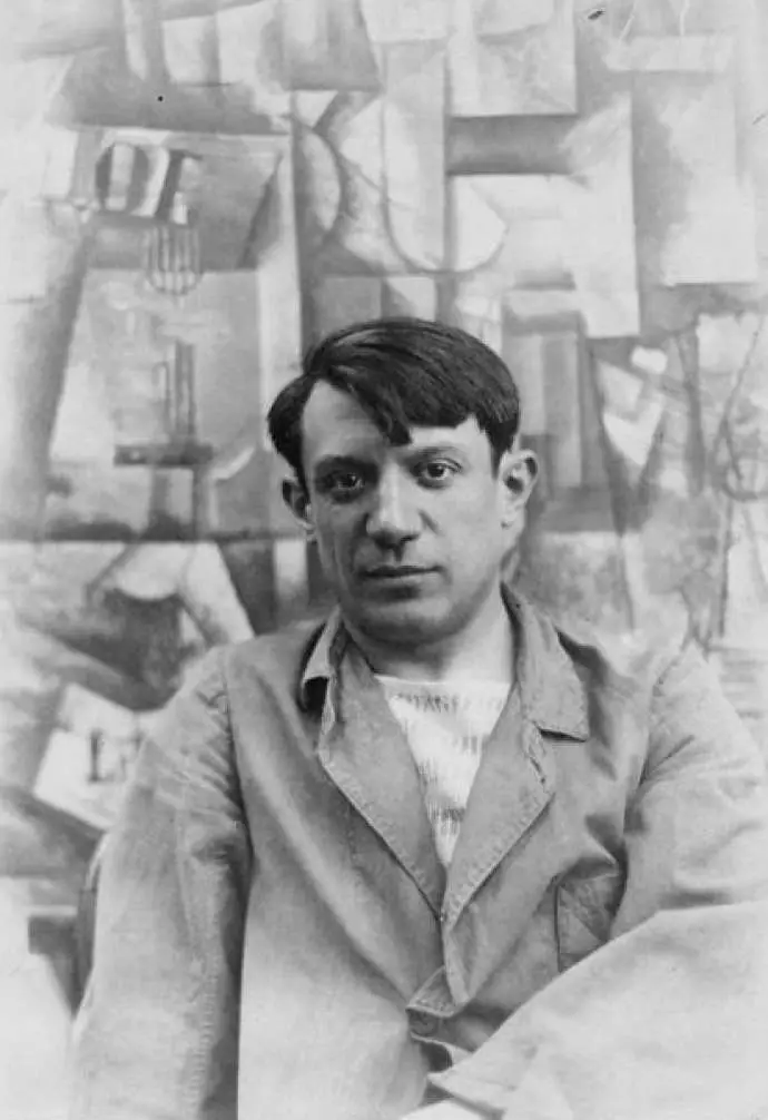 Portrait photograph of Pablo Picasso, in front of his painting The Aficionado (Kunstmuseum Basel) at Villa les Clochettes, Sorgues, France, summer 1912