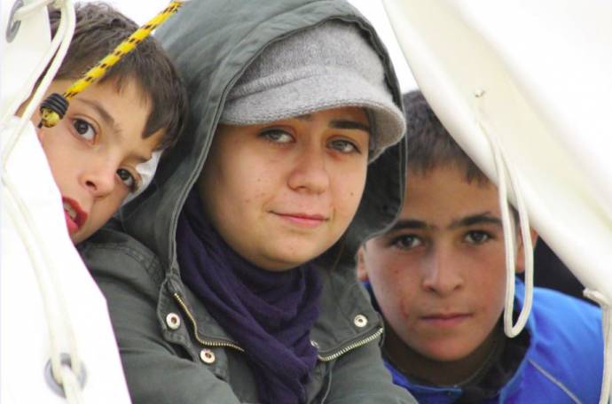 A family waits for food aid from Caritas Slovenia at Livarna refugee camp, Dobova, Slovenia, 2015