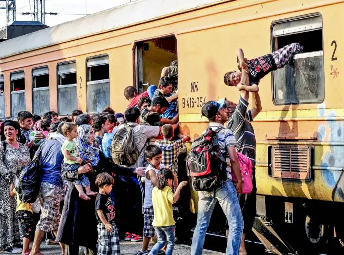 &quot;Migrants clamber onto a train at Gevgelija train station in Macedonia, close to the border with Greece July 30, 2015&quot;