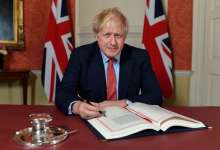 British PM Boris Johnson proudly signing the deal he negotiated, sold to the public as 