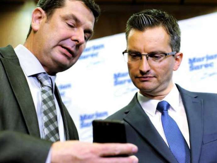 Good news for Prime Minister Marjan Šarec, right, with Brane Krajl holding the phone