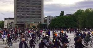 Protesters cycling around Trg Republike / Republic Square, in front of Parliament (off screen, to the right)